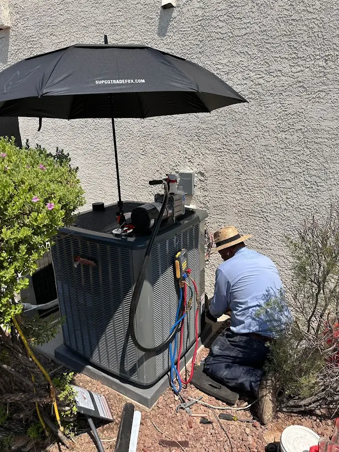 HVAC technician performing outdoor AC maintenance in West Caln